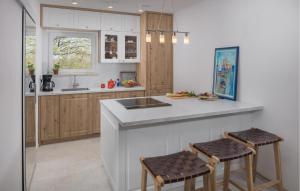 a kitchen with a sink and a counter with stools at Beautiful Home In Buje in Buje
