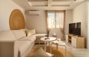 uma sala de estar com um sofá branco e uma televisão em Stunning Home In Vrboska With Kitchen em Vrboska