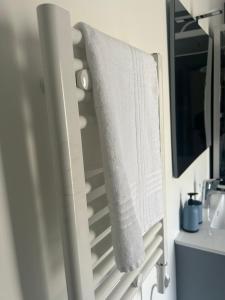 a towel hanging on a towel rack in a bathroom at Lumineux Appart à Disneyland in Montry +17 photos