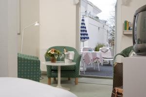 a room with chairs and a table with flowers on it at Hotel Parkfrieden in Timmendorfer Strand