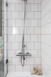 um chuveiro na casa de banho com azulejos brancos em Luxury & Spacious 2 BR APT with City Views em Londres