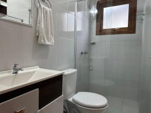 a bathroom with a toilet and a sink and a shower at Apartamento Coração de Gramado in Gramado +43 photos