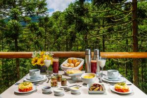 a table with breakfast foods and drinks on a balcony at Pousada Casa Campestre in Gonçalves