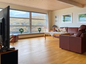 a living room with a couch and a tv at Sea & Mountain View 3 Bedroom in Leynar