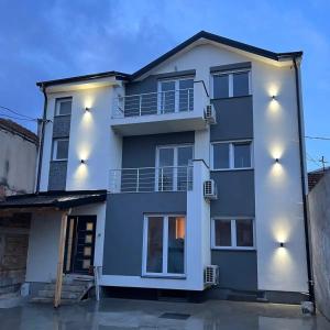 une maison blanche éclairée dans l'établissement Apartman Milos, à Vranje