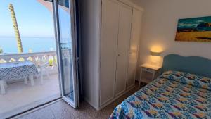 a bedroom with a bed and a balcony with the ocean at Casa del Mare in Ischia