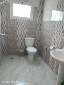 a bathroom with a toilet and a sink and a window at Résidences Porte de désert Douz in Douz