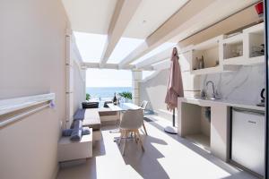 a kitchen with a table and chairs and the ocean at Agios Gordios Boutique Resort in Agios Gordios