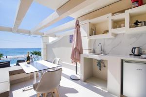 Agios Gordios Boutique Resort في آغيوس غوذيوس: مطبخ وغرفة طعام مطلة على المحيط