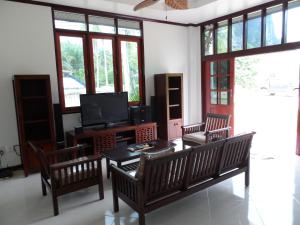 a living room with three chairs and a television at PARADIS VERT in Ban Khao Thong