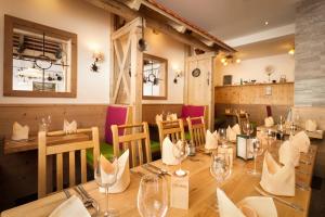 um restaurante com uma longa mesa e cadeiras de madeira em Der Sailer Hotel & Restaurant em Obertauern