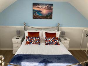 a bedroom with a large bed with blue walls at Braemar in Weymouth