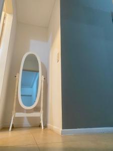 a round mirror in a room with a blue wall at Mar in Junín