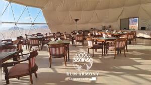 ein Restaurant mit Tischen und Stühlen in einem Zelt in der Unterkunft Armony rum camp in Wadi Rum