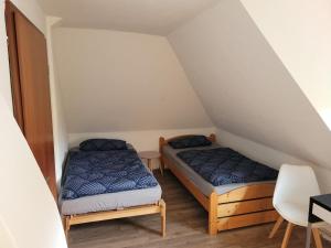 Habitación con 2 camas y silla en City- und Messeapartment Hildesheim, en Hildesheim
