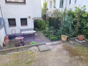 a garden with a bench and plants in front of a building at City- und Messeapartment Hildesheim in Hildesheim +7 photos