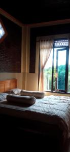 ein Bett mit zwei Kissen und einem Fenster in der Unterkunft Toraja Bungin Homestay in Rantepao