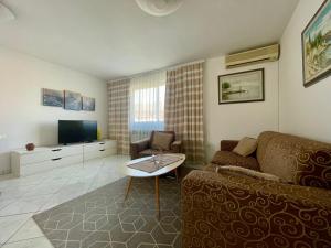 - un salon avec un canapé et une télévision dans l'établissement Apartments Maria, à Umag