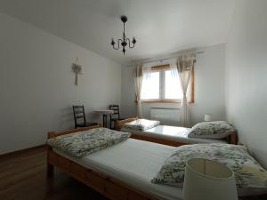 a bedroom with three beds and a window at Maślana Chata in Sokolec