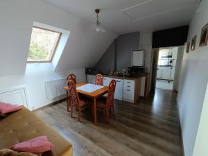 a kitchen and dining room with a table and chairs at Maślana Chata in Sokolec