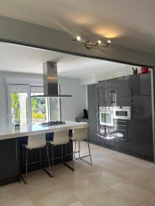 a kitchen with a table and chairs in a room at Magnifique villa l'Ibis pour 8 personnes, piscine, clim,parc et parking in Arles