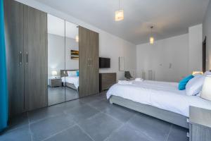 a bedroom with a large bed and a mirror at Private duplex home in the heart of St Julians in St Julian's