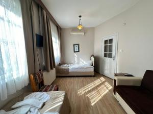 um quarto com duas camas e um sofá em Buhara Family Stone House em Istambul