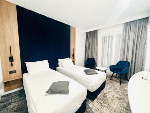 Habitación de hotel con 2 camas y pared azul en Hotel Soimul, en Poiana Brasov