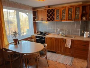 a kitchen with wooden cabinets and a table and a table and chairs at Family house room in Salacgrīva