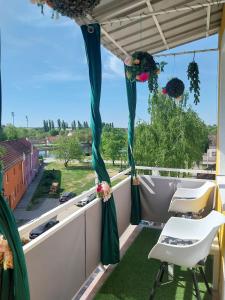 a balcony with blue curtains and flowers on it at 7.Nebo/ Spa apartman Vinkovci in Vinkovci