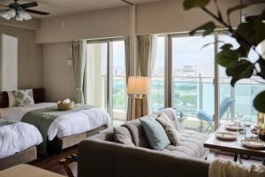 a bedroom with a couch and a bed and a window at Casa YONNA Naha in Naha