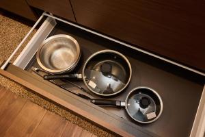 a counter top with three pans on top of it at Casa YONNA Naha in Naha