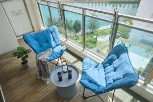 a living room with two chairs and a large window at Casa YONNA Naha in Naha