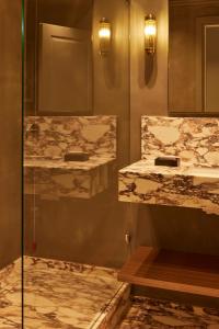 baño con 2 lavabos y ducha de cristal en Living Suites, en Milán