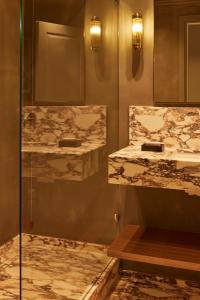 a bathroom with two sinks and a glass shower at Living Suites in Milan