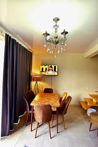 una sala da pranzo con tavolo, sedie e lampadario pendente di Chalet Resort Weekend Borjomi a Borjomi