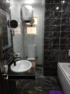 - une salle de bains en noir et blanc avec lavabo et toilettes dans l'établissement زهراء المعادي الطريق الدائري بجوار مودرن اكاديمي وكارفور, au Caire