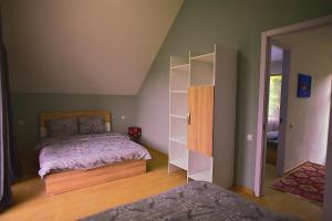 1 dormitorio con cama y estante para libros en Chalet Resort Weekend Borjomi, en Borjomi