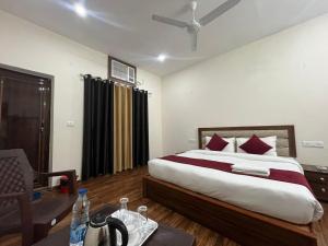 - une chambre avec un lit et une chaise dans l'établissement Hotel Badal Inn - Safdarjung Enclave, à New Delhi