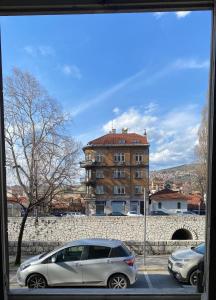 ein silbernes Auto, das vor einem Gebäude parkt in der Unterkunft Waterfall Hostel in Sarajevo