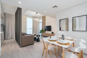 a dining room and living room with a table and chairs at Tamm - Noor 2 Tower in Dubai