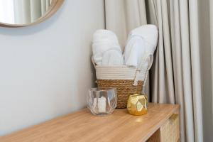 a basket of towels on a table with a glass at Tamm - Noor 2 Tower in Dubai