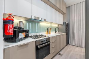 a kitchen with a stove top oven next to a sink at Tamm - Noor 2 Tower in Dubai