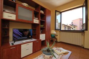 a living room with a tv and a large window at Sunrise in Baveno in Baveno