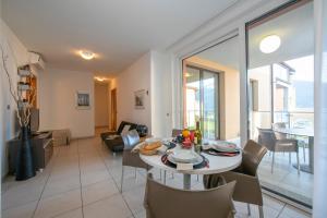 een eetkamer en een woonkamer met een tafel en stoelen bij Vista di Maccagno Fantastico Pool in Maccagno Superiore