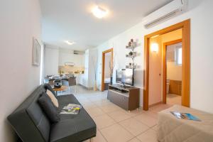 a living room with a couch and a television at Vista di Maccagno Fantastico Pool in Maccagno Superiore