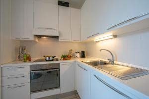 a kitchen with white cabinets and a sink at Vista di Maccagno Fantastico Pool - Happy Rentals in Maccagno con Pino e Veddasca