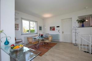 ein Wohnzimmer mit einem Tisch und einem Esszimmer in der Unterkunft Residenza due Laghi Pool Lake View in Brezzo