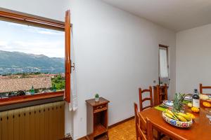 uma sala de jantar com uma mesa e uma janela em Oasi di Castelveccana Apt Pool and View em Castelveccana