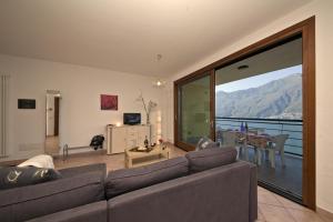 a living room with a couch and a large window at Va Pensiero sul lago Stunning View in Tronzano Lago Maggiore